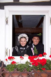 Ein Mann und eine Frau, die aus dem Fenster schauen in der Unterkunft Quartier vert in Hunspach