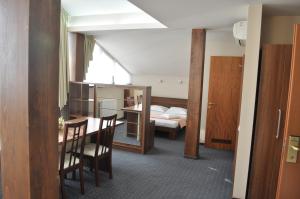a room with a bed and a table and chairs at Euro House Hotel in Baia Mare