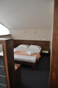 a bedroom with a bed with a wooden headboard at Euro House Hotel in Baia Mare