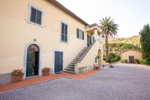 ポルトフェッラーイオにあるBilo Sant'Anna con vista piscinaの階段とヤシの木のある白い家