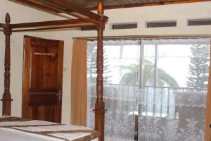 a bedroom with a bed and a large window at Sukuh Cottage in Tawangmangu
