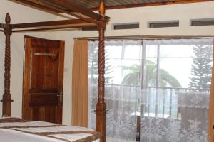 - une chambre avec un lit et une grande fenêtre dans l'établissement Sukuh Cottage, à Tawangmangu