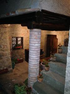 LamoleにあるAntica Torre nel Cuore del Chiantiの鉢植えの柱付き石造りの家