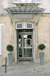 a door leading to a building with a large window at Hôtel Atlantic in La Rochelle