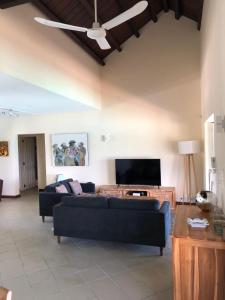 Una sala de estar con un sofá y un televisor de pantalla plana. en Grand Baie Seaview Penthouse, en Grand Baie