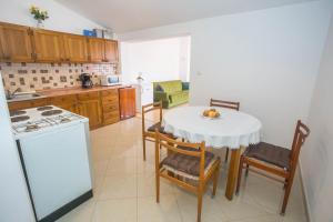 eine Küche mit einem Tisch und Stühlen sowie einem weißen Tisch in der Unterkunft Apartments Katica in Gedići