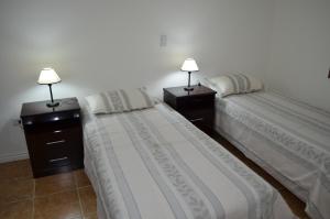 2 letti posti uno accanto all'altro in una camera da letto di Departamento Ciudad De Santa Rosa a Santa Rosa