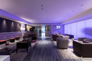 a hotel lobby with couches and tables and purple lighting at Catalonia Square 4* Sup in Barcelona