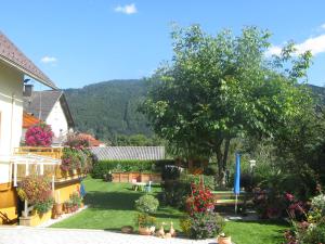 een uitzicht op een huis met een tuin met bloemen bij Ferienwohnung Stichauner in Bodensdorf