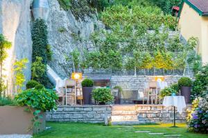 un restaurant avec des tables et des chaises dans un jardin dans l'établissement Genießerhotel Döllerer, à Golling an der Salzach