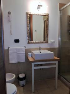 a bathroom with a toilet, sink, and mirror at Marvi Hotel in Rome
