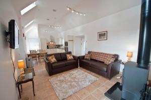 a living room with two brown couches and a kitchen at Lady Macbeths Rest in Banchory