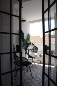 リスボンにあるCampo de Santa Clara 98の椅子2脚と植物テーブル1台が備わる部屋