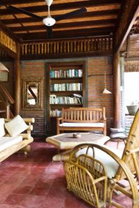 a living room with two benches and bookshelves at Rumah Kita in Lovina