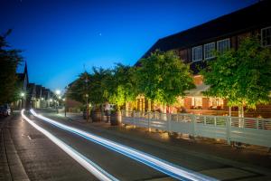 uma rua da cidade à noite com faixas de luzes em Hotel Rheinischer Hof em Dinklage
