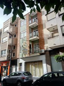 a apartment building with cars parked in front of it at Pension Centro in Guardamar del Segura