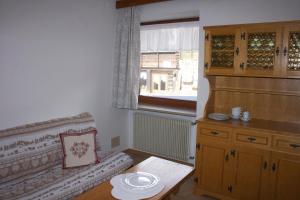 - un salon avec un canapé, une table et une fenêtre dans l'établissement Pilat, à Vigo di Fassa
