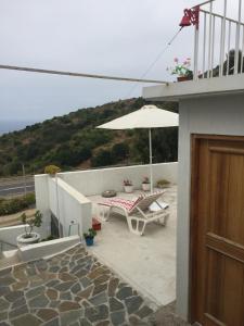 a patio with a table and an umbrella at Alojamiento Independiente in Zapallar +6 photos