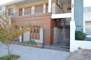 ein Backsteingebäude mit einem Balkon und einer Treppe in der Unterkunft Departamento Ciudad De Santa Rosa in Santa Rosa