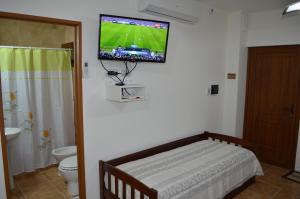 ein Bad mit einem Bett und einem TV an der Wand in der Unterkunft Departamento Ciudad De Santa Rosa in Santa Rosa