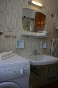 a bathroom with a sink and a washing machine at Pilat in Vigo di Fassa