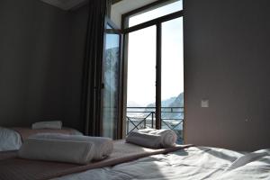 1 Schlafzimmer mit 2 Betten und einem großen Fenster in der Unterkunft Hotel Elegant in Kazbegi