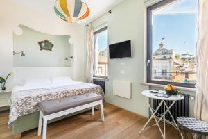 niewielka sypialnia z łóżkiem i oknem w obiekcie Rarity Suites w Rzymie