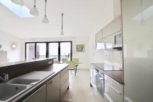a white kitchen with a sink and a counter at Appartement T4 Vue Unique in Rodez