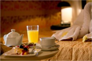 una mesa con un plato de comida y un vaso de zumo de naranja en Visir Resort Spa, en Mazara del Vallo