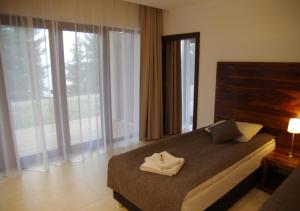 Un pat sau paturi într-o cameră la M Club Hotel | Lubie Resort