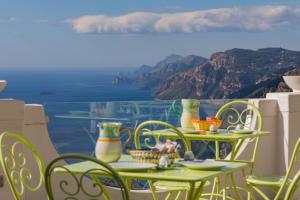 a table topped with a glass of water next to a beach at Bacio del Sole B&B Positano in Positano