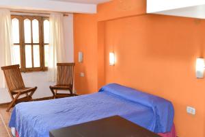 a bedroom with orange walls and a bed and two chairs at Cabañas Villa Lounge in San Rafael +37 photos