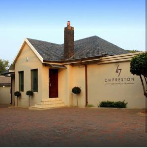 un edificio blanco con un cartel en el costado en 47 On Preston Guesthouse, en Johannesburgo
