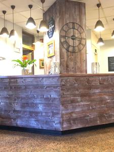 un bar en bois avec une horloge sur le mur dans l'établissement Hôtel Les Trappeurs, aux Orres