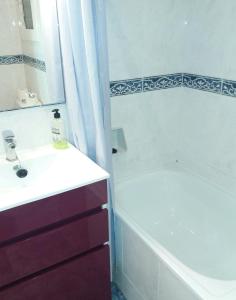 ein Badezimmer mit einer weißen Badewanne, einem Waschbecken und einer Badewanne in der Unterkunft Apartamento Sagrada Familia in Barcelona + 21 Fotos
