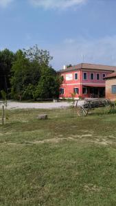 un edificio rojo con un cañón en un campo en Barone Rosso, en Treviso