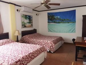 a hotel room with two beds and a ceiling fan at Easy Inn Hotel in Belize City