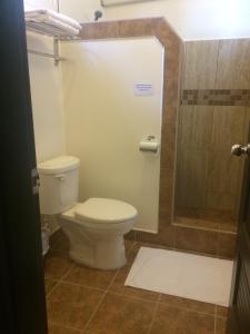 uma casa de banho com um WC e um chuveiro em Easy Inn Hotel em Cidade de Belize