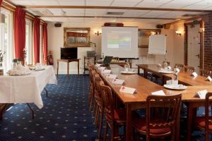 a conference room with tables and chairs and a screen at The Dog & Bear Hotel in Lenham