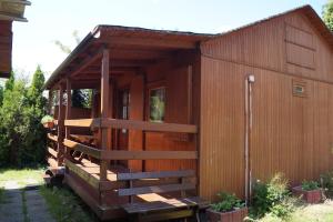a wooden cabin with a staircase in a yard at Domki " ELRINO " in Jastarnia