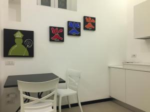 a kitchen with a table and four paintings on the wall at Residenza Santa Lù B&B in Naples