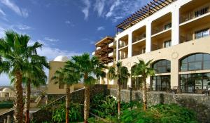 a building with palm trees in front of it at Vincci Selección La Plantación del Sur in Adeje