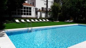 a large swimming pool with chairs and a house at Hotel Rural Villa Onuba in Fuenteheridos