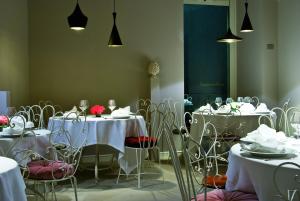 a dining room with tables and chairs with white table cloth at Shalai in Linguaglossa
