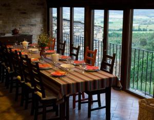 a dining room table with chairs and a large window at O Chardinet d'a Formiga in Aínsa