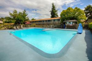 a large blue swimming pool with chairs and a building at Red Lion Hotel Bellevue in Bellevue