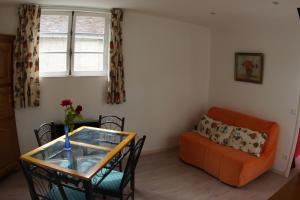 ein Wohnzimmer mit einer Couch und einem Glastisch in der Unterkunft le petit nid in Neuillé-le-Lierre