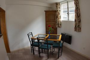 einen Esstisch mit Stühlen und einen TV in der Unterkunft le petit nid in Neuillé-le-Lierre