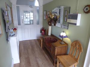 a living room with a couch and a chair and a mirror at The Grange Guest House in Brecon