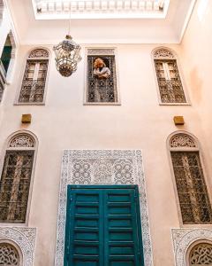 un edificio con una puerta verde y ventanas en Riad Anata, en Fez